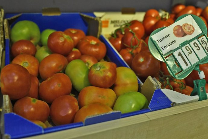 Imagen de archivo de cajas de tomates variados en un mercado 