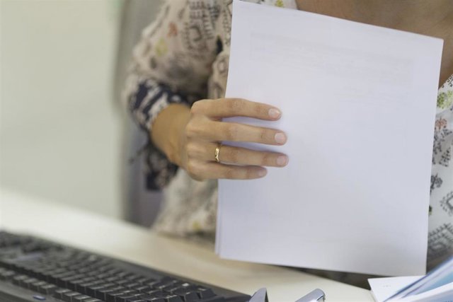 Una trabajadora en una mesa de oficina.
