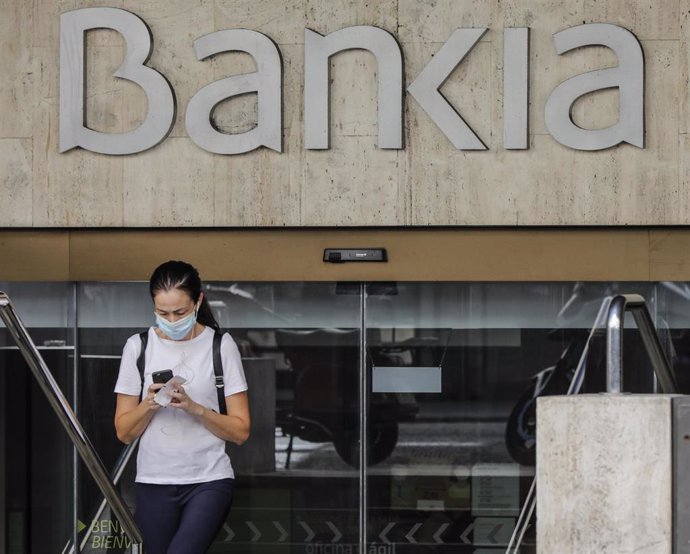 Una mujer sale de la sede de Bankia en Valencia, Comunidad Valenciana (España), a 4 de septiembre de 2020. CaixaBank y Bankia estudian emprender un proceso de fusión con el fin de aumentar su rentabilidad ante la crisis provocada por la pandemia del Cov
