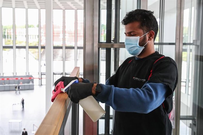 Un trabajador desinfectando una barandilla en la feria IFA en Berlín