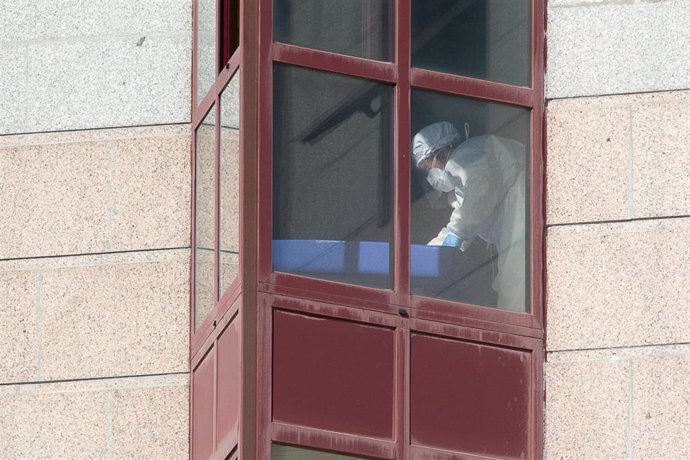 Un trabajador protegido es visto por uno de los cristales de la residencia de mayores DomusVi de Outeiro de Rei en Lugo, Galicia (España), a 8 de septiembre de 2020. La Xunta ha intervenido el geriátrico tras detectar 99 positivos más en covid-19, 94 de