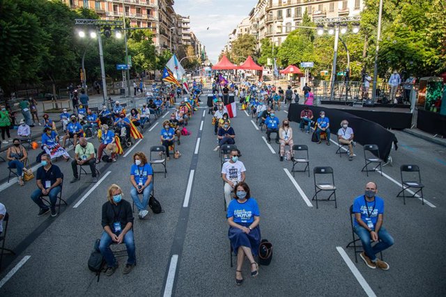 Participantes sentados en las sillas de separación el acto de la ANC, Òmnium y la AMI por la Diada en la plaza Letamendi de Barcelona