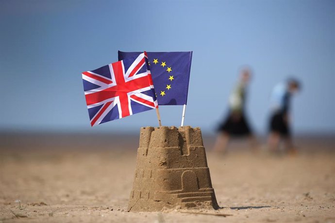 Brexit. Banderas de Reino Unido y la UE sobre un castillo de arena