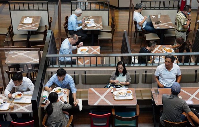 Un grupo de personas come en un restaurante de Hong Kong siguiendo las normas de distanciamiento social impuestas para evitar más contagios por coronavirus.
