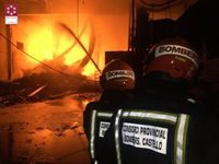 Bomberos trabajan en la extinción de un incendio en una planta de reciclaje de Cervera del Maestre (Castellón)