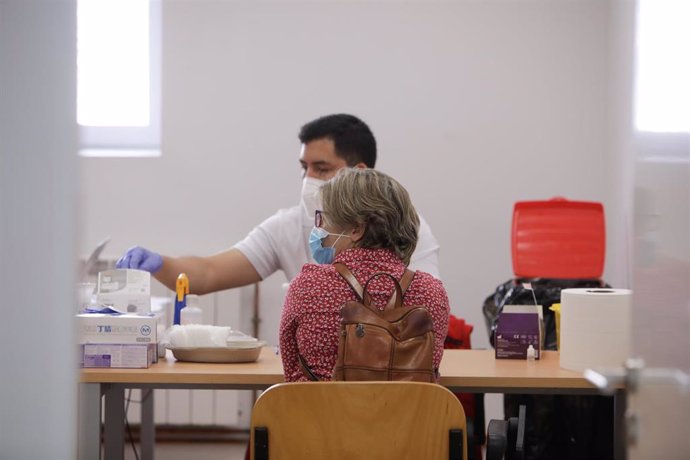 Un sanitario de Cruz Roja realiza a una mujer un test rápido de detección de anticuerpos IgG e IgM utilizado en el Instituto de Formación Integral en Seguridad y Emergencias (IFISE), en Colmenar Viejo, Madrid (España).