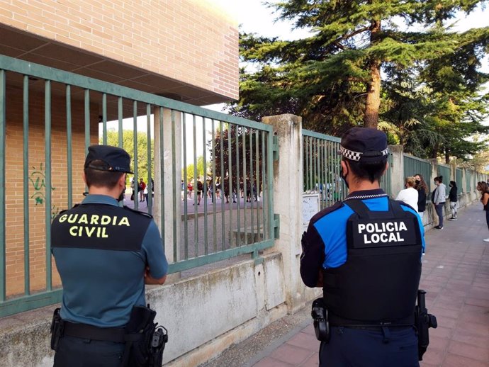 Agentes de Guardia Civil y Policía Nacional revisan el cumplimiento de las normas y que el regreso de los alumnos a la enseñanza presencial se haga de forma ordenada y segura a la puerta del I.E.S. Emilio Ferrari de Valladolid.