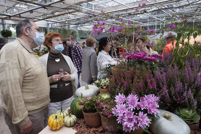 Visitantes con mascarilla en un festival de flores en un jardín botánico de Moscú