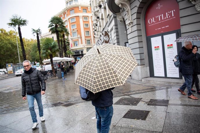 Una persona pasea por la calle con un paraguas debido a la lluvia 