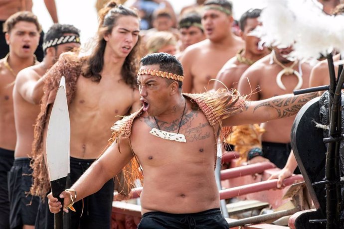 Varios maoríes interpretando una haka en la playa de Te Tii 