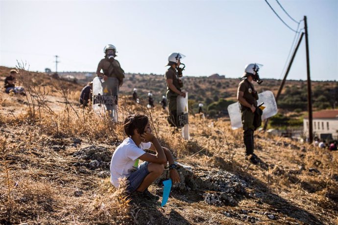 Un niño frente a la Policía de Grecia durante una protesta de migrantes que piden su reubicación después de que varios incendios destruyeran el campamento de Moria, en la isla de Lesbos.