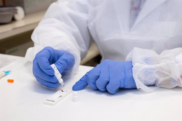 Una manos de sanitario con guantes de nitrilo realizan un test