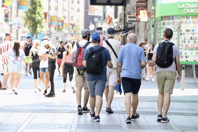 Un grupo de hombres caminan por una calle de Madrid.