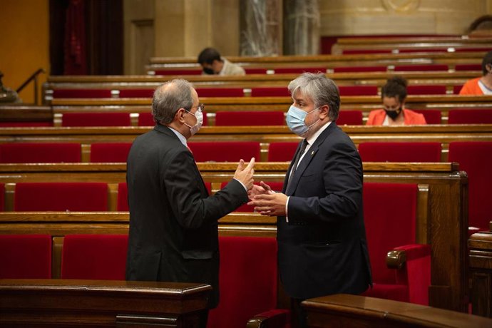 El presidente de la Generalitat, Quim Torra (i), mantiene una conversación con el presidente de JxCat en el Parlament, Albert Batet, en el pleno del Parlament, a 9 de septiembre de 2020.