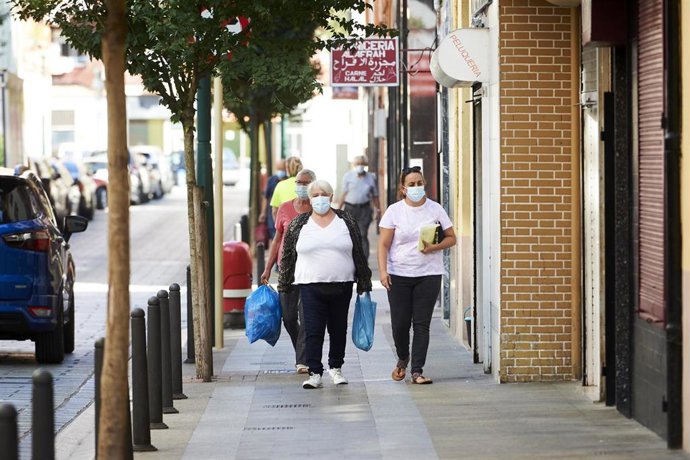 Transeúntes pasean por las calles del barrio La Inmobiliaria de Torrelavega