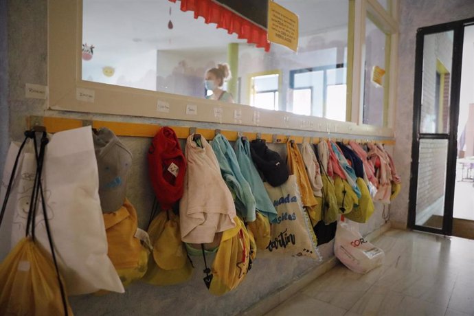 Chaquetas de los alumnos colgadas en la pared de una Escuela Infantil , foto de archivo