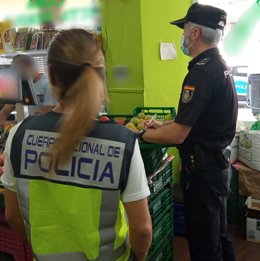 Dos agentes en una de las fruterías.