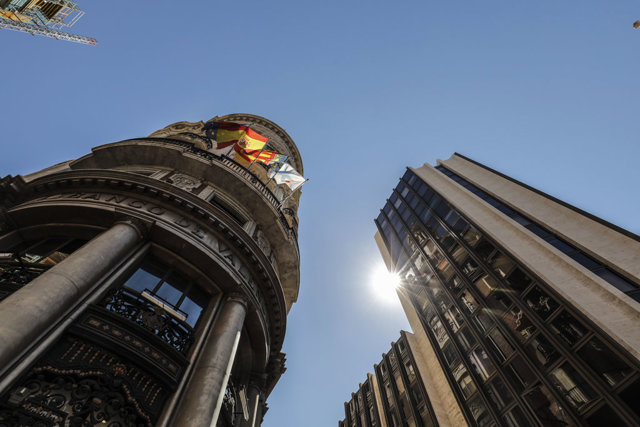 Banderas de la UE, España, Comunidad Valenciana y Caixa ondeando en los balcones de la sede de Caixabank, en Valencia.