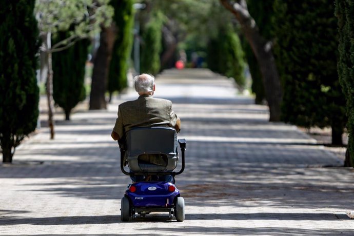 Un anciano en silla de ruedas eléctrica en un parque, en Madrid (España), a 2 de mayo de 2020. .