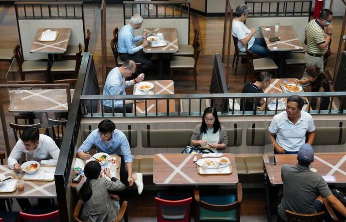 Un grupo de personas come en un restaurante de Hong Kong siguiendo las normas de distanciamiento social impuestas para evitar más contagios por coronavirus.