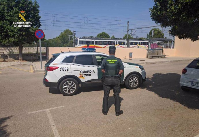 Agente de la guardia civil junto a un coche en la estación de Es Figueral