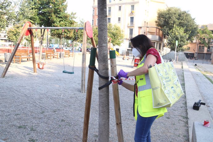 Pla general d'una treballadora de l'Ajuntament de Girona precintant el parc infantil dels Jardins de la Infncia el 16 de setembre de 2020 (Horitzontal)