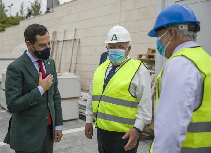 El presidente de la Junta, Juanma Moreno(1d), saluda con la mano en el corazón  a el consejero de Salud, Jesús Aguirre (c)  al comienzo de  la visita de las obras de remodelación del Hospital de la Merced. Osuna, Sevilla a 17 de septiembre 2020