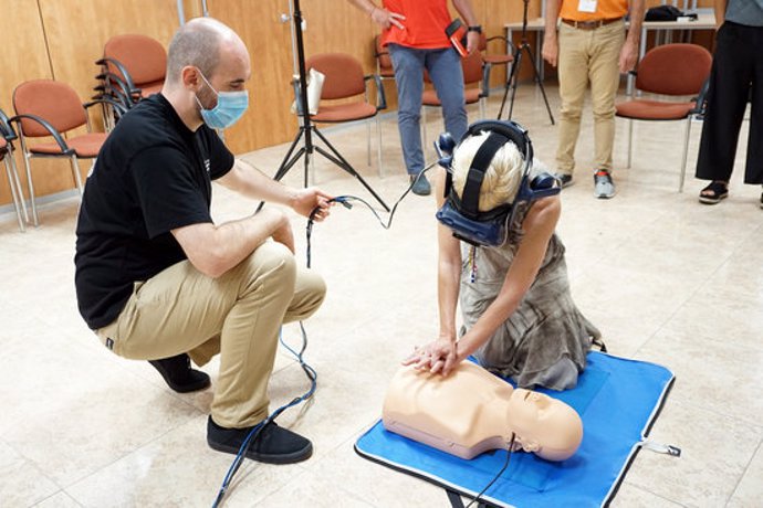 Pla general d'un professor i una alumna amb les ulleres virtuals fent un massatge de reanimació durant una classe el 17 de setembre del 2020. (horitzontal)