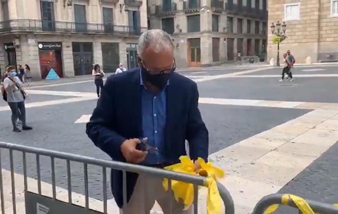 El presidente del PP en el Ayuntamiento de Barcelona, Josep Bou, quitando lazos amarillos de la entrada del consistorio.
