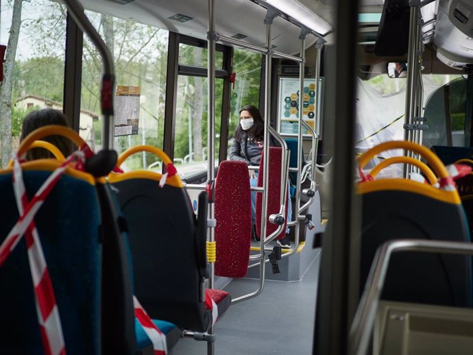 Una mujer protegida con mascarilla viaja en un autobús urbano de Pamplona.