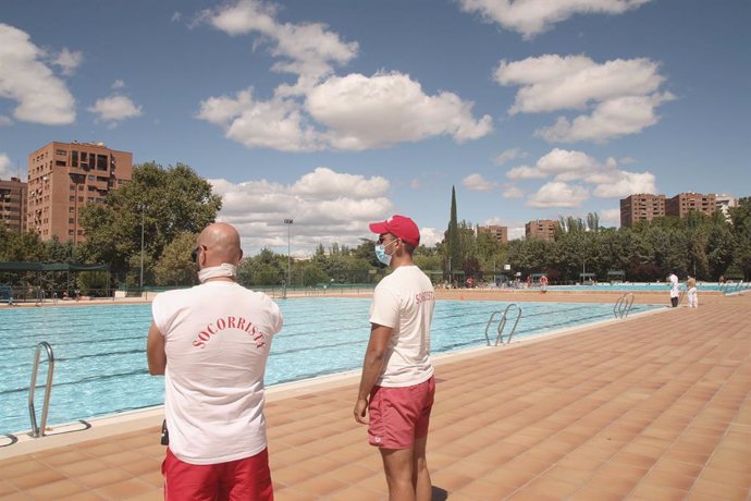 Dos socorristas vigilan la piscina del Polideportivo Vicente del Bosque en Madrid  antes de su cierre por adelantado el 1 de septiembre junto al resto de piscinas municipales de la ciudad, una medida para evitar más propagaciones del coronavirus ante lo
