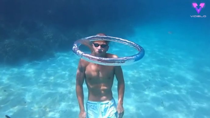Un joven graba a una medusa atrapada dando vueltas en un anillo de agua