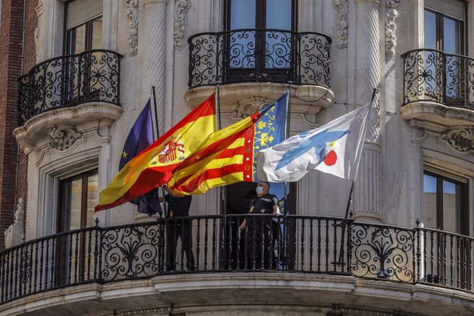 Banderas de la UE, España, Comunidad Valenciana y Caixa ondeando en los balcones de la sede de Caixabank, en Valencia,