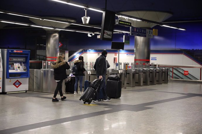 Varios turistas hacen uso del metro de la estación de Nuevos Ministerios, en Madrid (España), a 24 de marzo de 2020.
