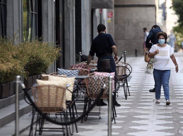 Un camarero prepara una terraza de un bar, en Madrid (España), a 7 de septiembre de 2020. Desde hoy, en la Comunidad de Madrid, el porcentaje de aforo permitido en las terrazas será del 100 por cien de las mesas permitidas en el año inmediatamente anterio