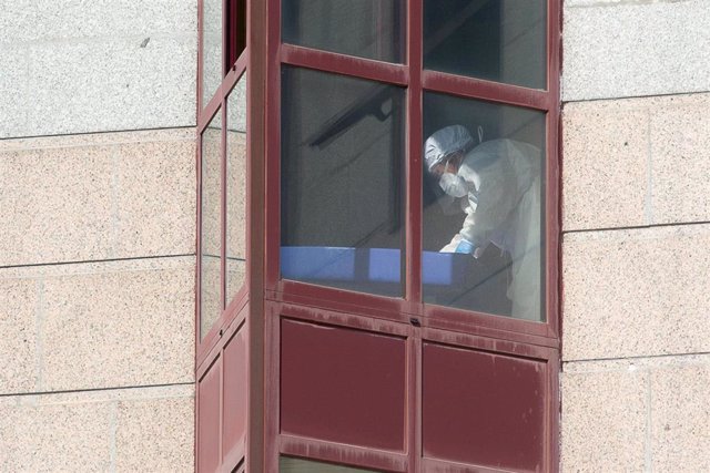 Un trabajador protegido es visto por uno de los cristales de la residencia de mayores DomusVi de Outeiro de Rei en Lugo, Galicia (España), a 8 de septiembre de 2020. La Xunta ha intervenido el geriátrico tras detectar 99 positivos más en covid-19, 94 de e