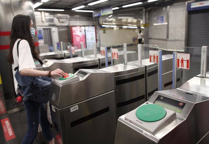 Una joven pasa su billete en el torno del Metro Plaza de España, en Madrid.