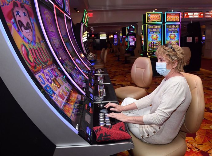 Una mujer con mascarilla en una máquina tragaperras de Las Vegas, Nevada, Estados Unidos