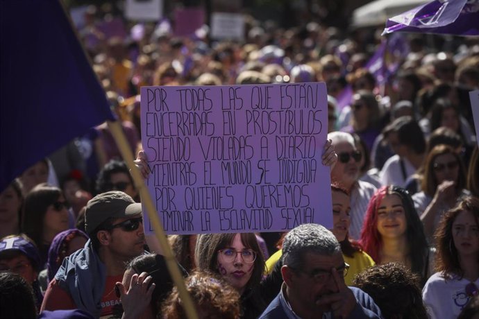 Una mujer sostiene su pancarta con un mensaje de protesta en contra de la prostitución durante la manifestación por el Día Internacional de la Mujer en Sevilla, (Andalucía, España), a 08 de marzo de 2020.