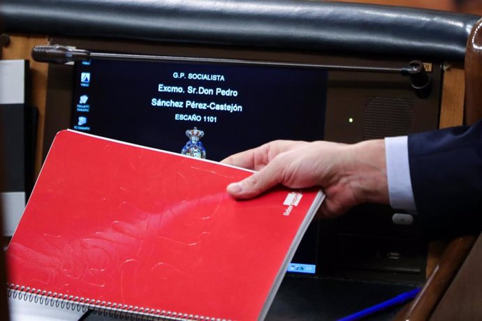 El presidente del Gobierno, Pedro Sánchez, deja su cuaderno de notas en la mesa de su escaño tras una intervención ante el Pleno del Congreso