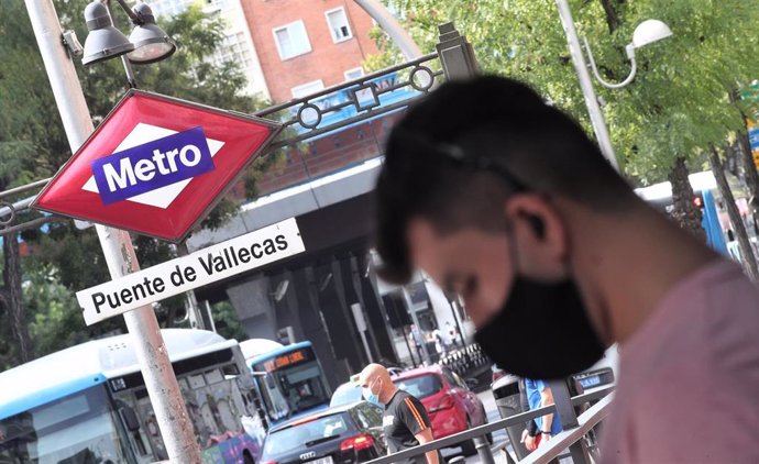 Vecinos pasean al lado del metro de Puente de Vallecas, en Madrid.