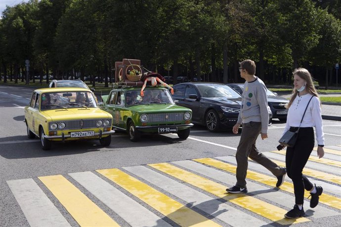 Dos ciudadanos pasean en Moscú durante una exhibición de coches Lada