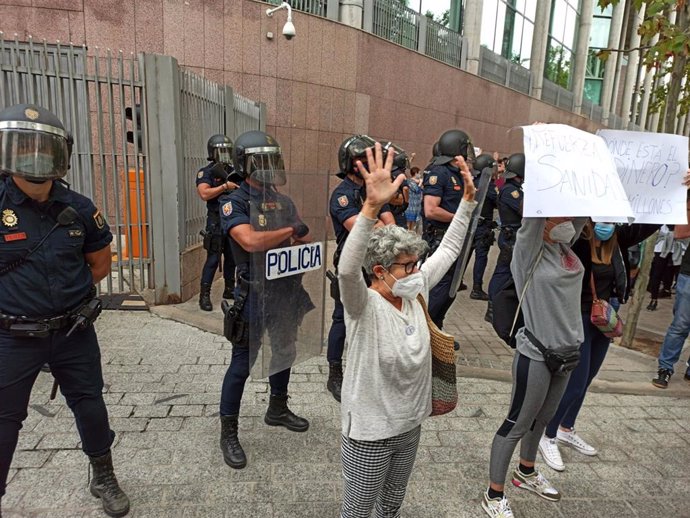 Participantes en una de las concentraciones contra los confinamientos selectivos en determinados distritos levantan las manos frente a la Asamblea como signo de protesta. En Puente de Vallecas, Madrid, (España), a 20 de septiembre de 2020.