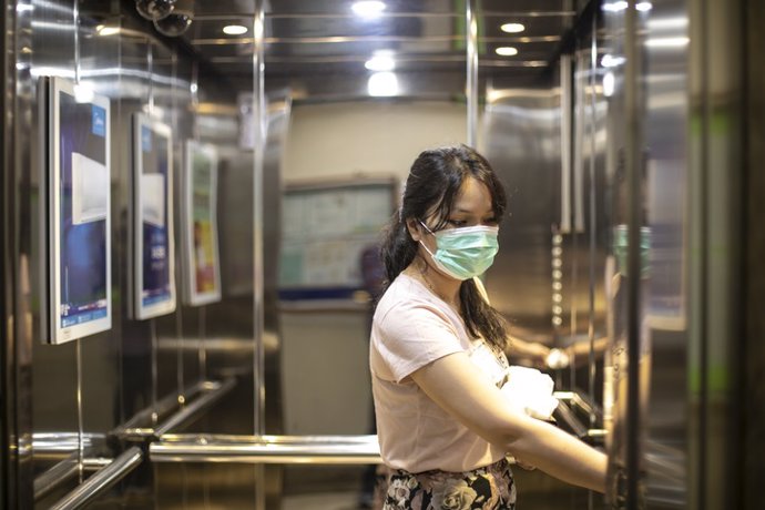 Ascensor, mujer con mascarilla