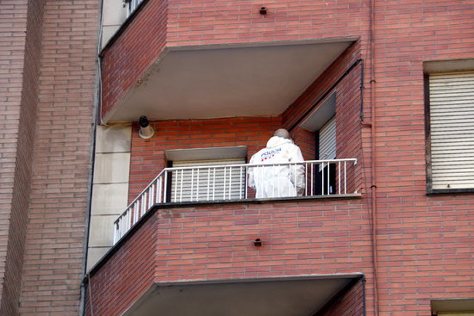 Un efectiu de la policia científica dels Mossos al balcó del pis de l'avinguda de les Garrigues de Lleida on ha tingut lloc l'homicidi. Imatge del 19 de setembre de 2020. (Vertical)