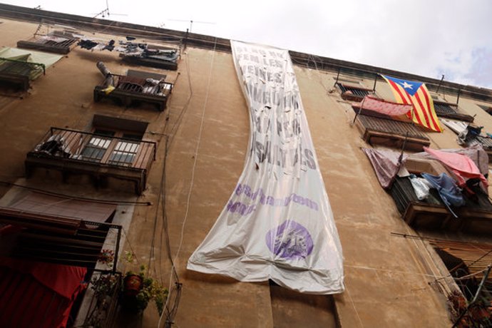 Pla contrapicat de l'edifici situat al número 6 del carrer Sant Bartomeu, al Raval, amb una pancarta penjant. Imatge del 21/09/2020 (horitzontal)