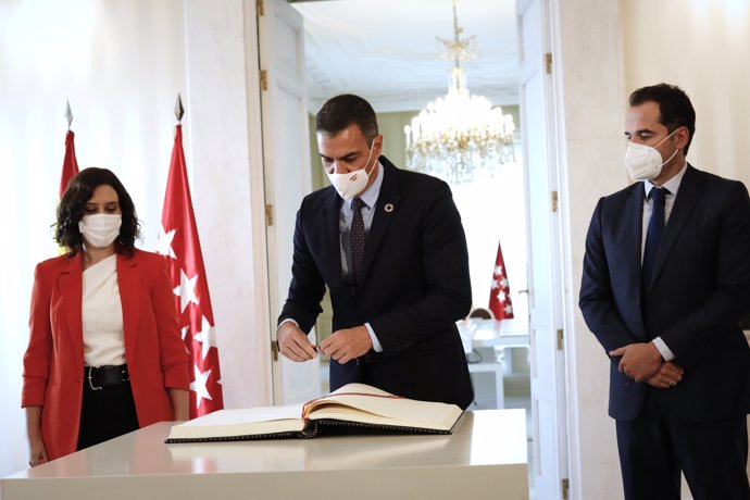 Acompañado de la presidenta y el vicepresidente de la Comunidad de Madrid, Isabel Díaz Ayuso e Ignacio Aguado, el jefe del Ejecutivo, Pedro Sánchez (c), firma en el libro de visitas.