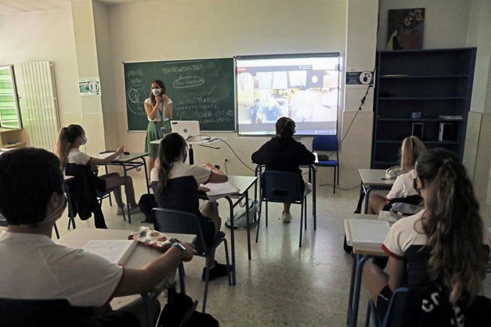 Alumnos atienden durante una clase semipresencial 