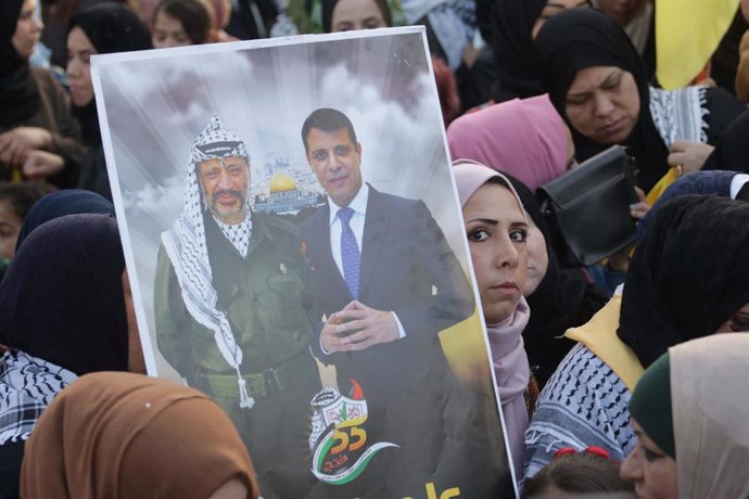 Una mujer palestina con un cartel de Yasir Arafat y Mohamed Dahlan
