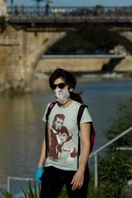Un hombre pasea con mascarilla y guantes junto al río Segura 